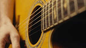 Young musician man sitting and playing acoustic guitar among music equipment in studio close-up. Guitarist plays melody  - Powered by Shutterstock - Get 15% off with code: PIKWIZARD15