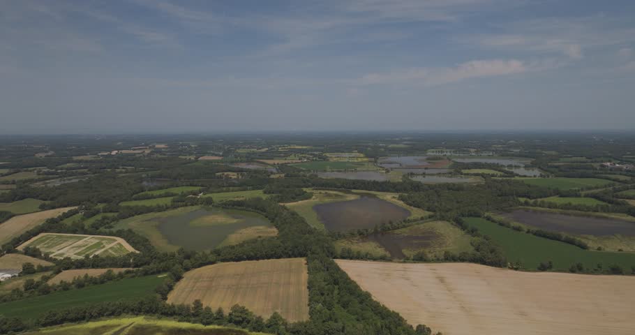 Aerial view of beautiful green fields and farmland under a sunny sky, Parc des Oiseaux, Marlieux, Ain, France.