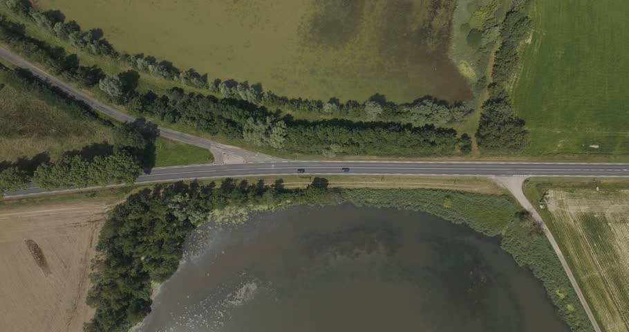 Aerial view of tranquil Parc des Oiseaux with lush green fields, serene ponds, and dense trees, Marlieux, France.