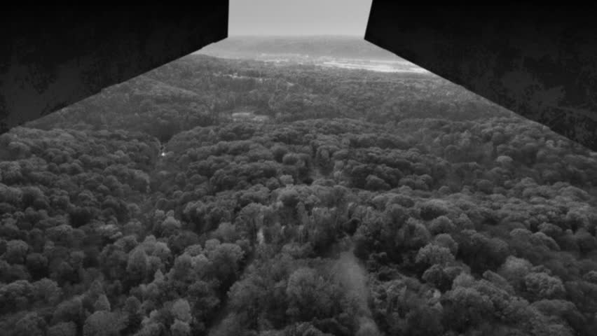 A grainy black and white film look view from inside a World War II plane carpet bombing the enemy landscape. Simulated.  	