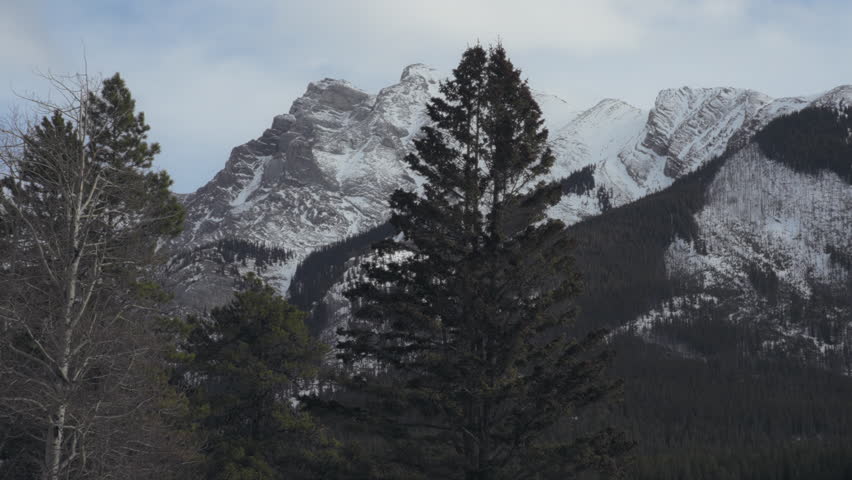 Snowy peaks of Rocky Mountains in winter. Banff National Park, Canada. Slow motion. 