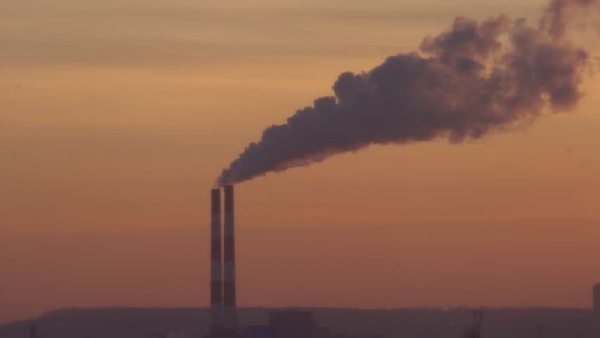 The two chimneys of the power plant give off white puffs of smoke, pollution of the atmosphere. Global warming Man's Carbon Footprint. Electricity production with fossil fuel concept. Polluting