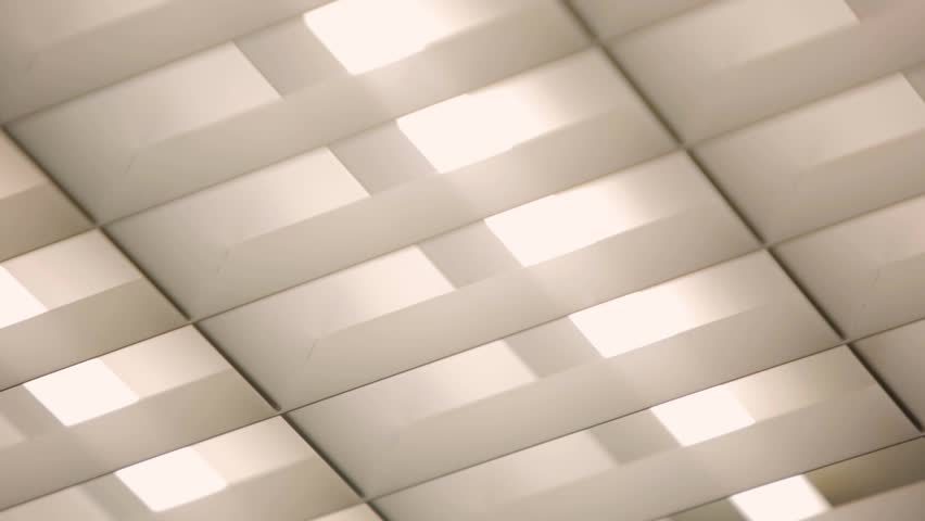 Fluorescent lights turning on in an office ceiling