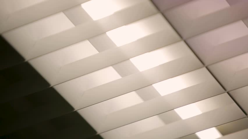 Fluorescent lights turning on in an office ceiling