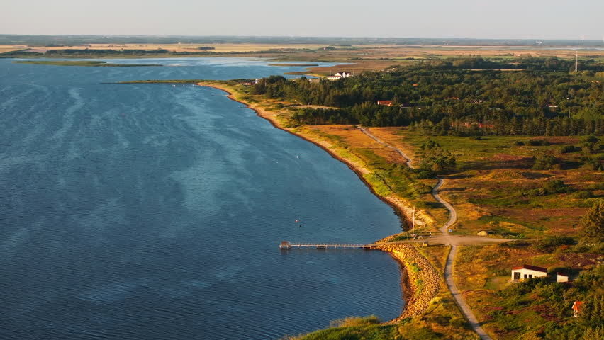 Ringkobing Fjord meets the North Sea on a sunny, clear day in Denmark. This aerial view shows the coastline and the waves meeting