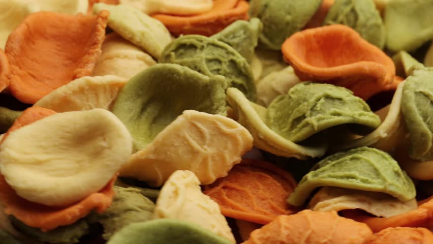 Dried tricolor Orecchiette pasta, rotation in circle. uncooked orecchiette pasta, Turning.