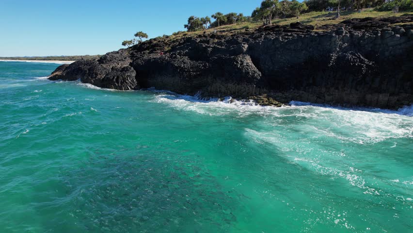 Ocean Waves Splashing On Rocky Fingal Headland With Mullet Fish Underwater In New South Wales, Australia. static shot