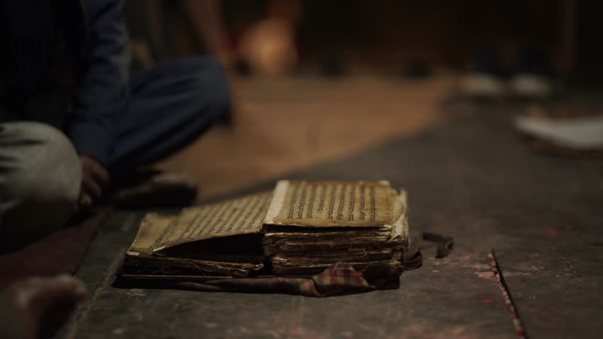 Old Man reading traditional scriptures in the Kathmandu Valley, Dark and Ancient scripture book