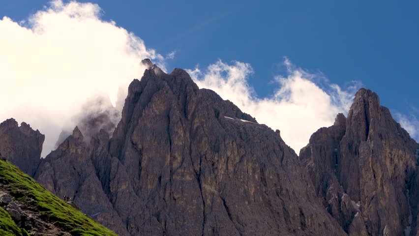  Mountain tops of  Dolomite Alps under blue sky. Clouds are running fast. Favorite place for hikers, alpinists, tourists.