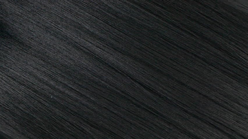 Closeup human long hair texture in slow motion, black straight hair background
