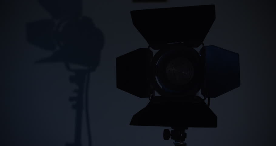 Video studio Fresnel lens spotlight on black background. lights slowly turn on and off. Close up.