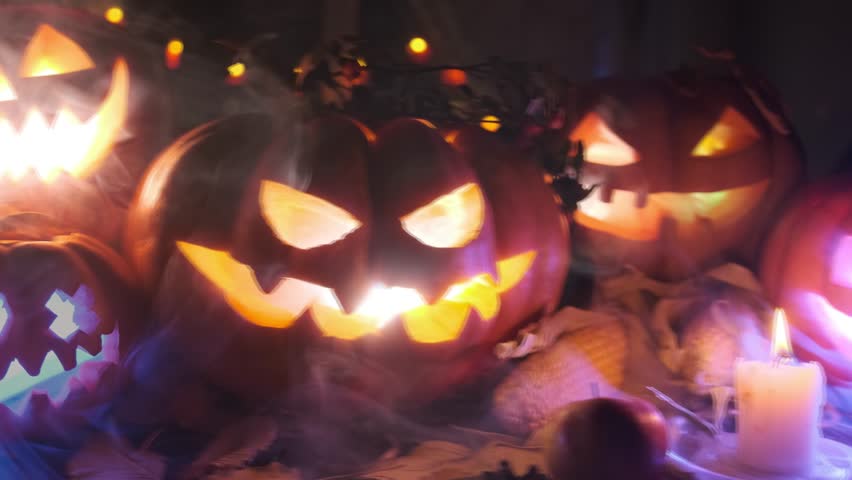 Creepy creative spooky decoration with halloween pumpkins flashing in the dark and thick fog by candlelight, party background. - Powered by Shutterstock - Get 15% off with code: PIKWIZARD15