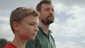 Father and teenage son take leisure walking along coastline of bay. Talking and sharing stories and jokes, smiling and enjoying togetherness. They stop to look at skyline. Family bonding - Powered by Shutterstock - Get 15% off with code: PIKWIZARD15
