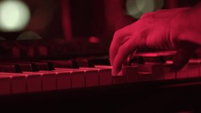 Pianist's Hand Playing Keyboard at Red-Lit Concert - Powered by Shutterstock - Get 15% off with code: PIKWIZARD15