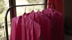 set of bright pink bridesmaid robes hanging neatly on a garment rack, ready for the wedding day - Powered by Shutterstock - Get 15% off with code: PIKWIZARD15