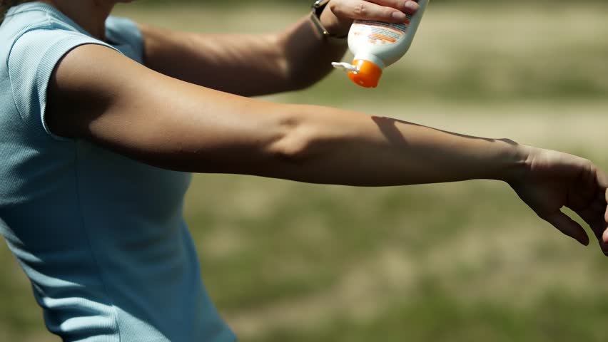 Woman Using Sunblock Lotion On Beach. Woman Applying Sunscreen Lotion On Body. Sunblock  Using Sun Block Cream Or Protective Moisturizer Before Sunbathing On Tanned Skin. Sunblock Lotion
