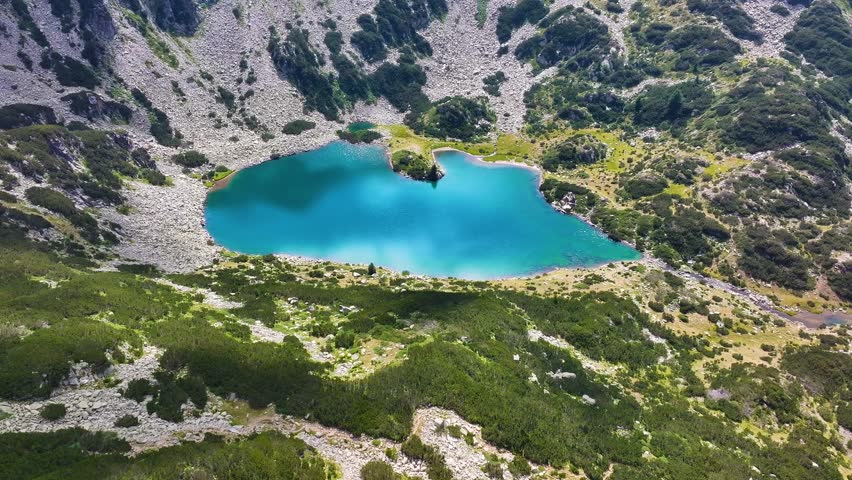 Ribno lake at Pirin mountain with glare, drone view from above