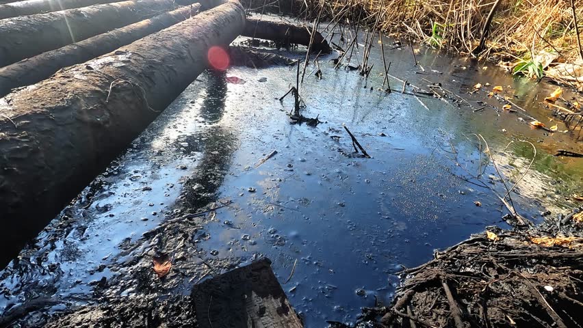 Oil pipes and valves of old rusty tank filled with oil leak and pollute the soil. Environmental protection issues 