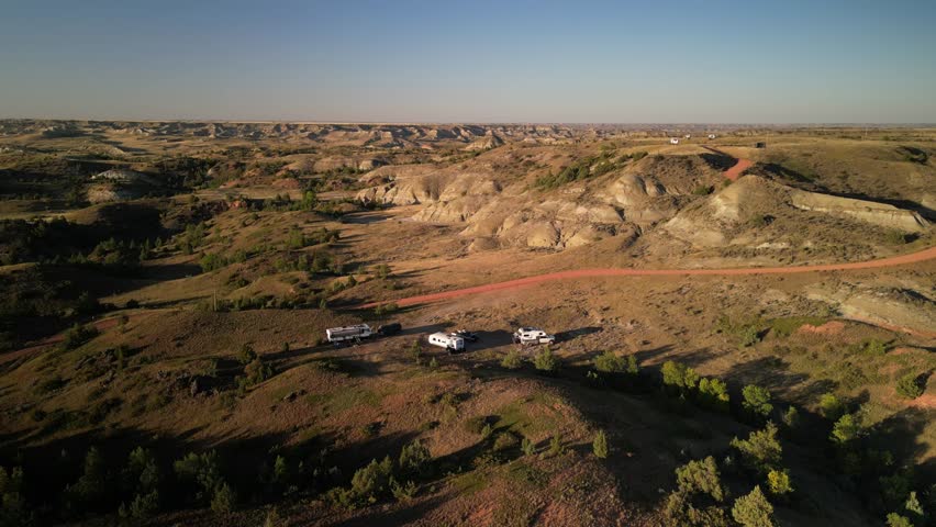 Aerial panning on RVs camped in Medora North Dakota badlands at sunset in National Grasslands