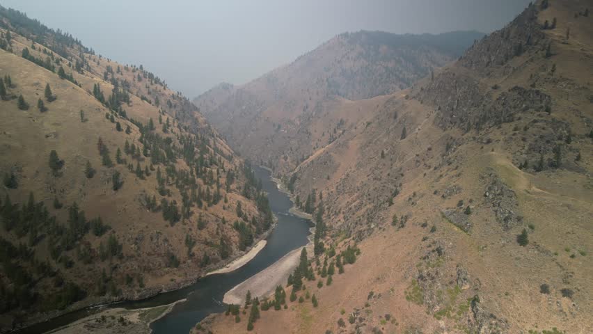 High aerial above Salmon River on smoky day in dry canyons in late summer in Idaho