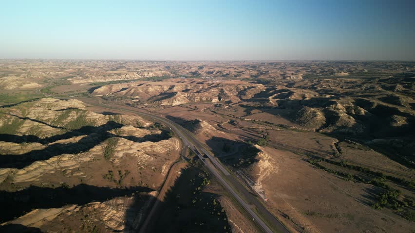 High aerial above Highway 94 through Medora North Dakota Badlands at sunset