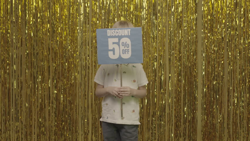 A little boy shows a poster with a discount offer