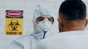 Laboratory worker in hazmat taking PCR throat sample for Covid-19 test from african american patient. Modern medical virology for coronavirus pneumonia or flu cure at science office - Powered by Shutterstock - Get 15% off with code: PIKWIZARD15