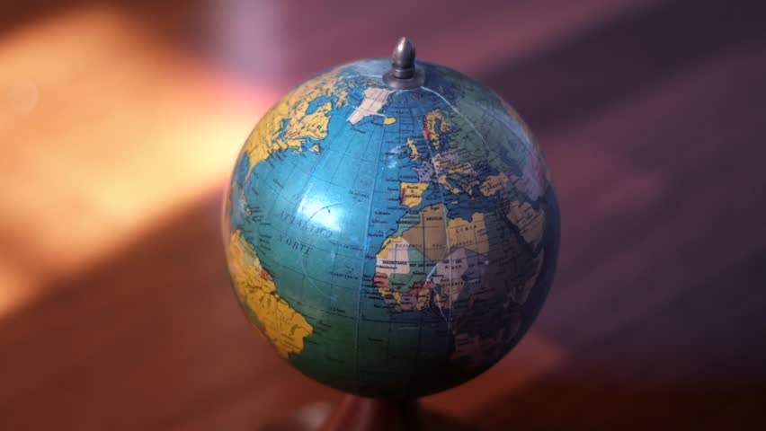 Close-up of a vintage globe spinning, showcasing continents