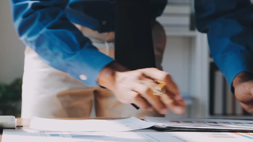 Business professionals meet to present new strategies, consult on financial documents, and plan for company market growth during a team session aimed at driving profits and expanding market