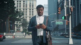 Timelapse Footage of an African American Man Standing and Using Smartphone on Busy City Street, Surrounded by Commuting Blurred Motion of Pedestrians. Portrait of a Black Male in Glasses - Powered by Shutterstock - Get 15% off with code: PIKWIZARD15