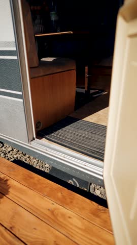 Woman wakes up in a camper, gets dressed and gets out of it. Concept of traveling with a camper. Vertical video