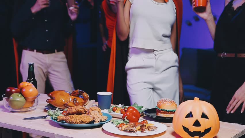 Four people dancing at a costume Halloween party in a house.