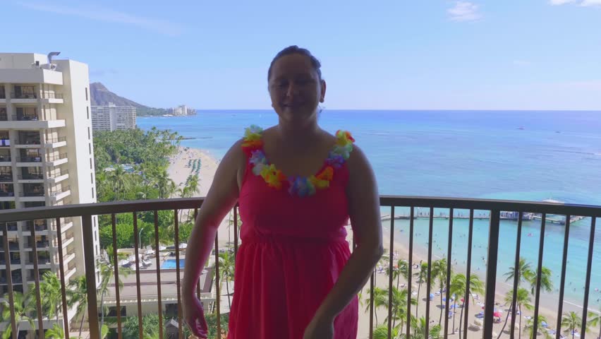 Woman dances the hula dance, in the background a beautiful view of Waikiki Beach in Honolulu, Hawaii from above in 4k slow motion 60fps