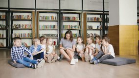 A dedicated teacher reads captivating stories to eager children in a lively library, fostering a love for literature and learning - Powered by Shutterstock - Get 15% off with code: PIKWIZARD15