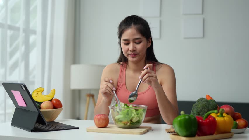 Young Asian woman in good health who is feeling anorexic. Doesn't want to eat. Woman is fasting in a salad bowl. Don't like or get bored with eating fresh, nutritious, tasty, healthy vegetables.