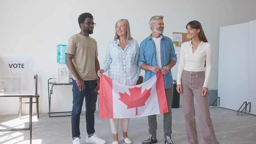Multi-ethnic group of people gathering together. Older couple holding big Canadian flag. Everyone looking directly at camera and positively smiling. Encouraging others to vote during elections.