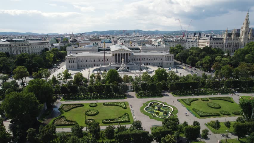 The austrian parliament surrounded by gardens and cityscape in vienna, aerial view