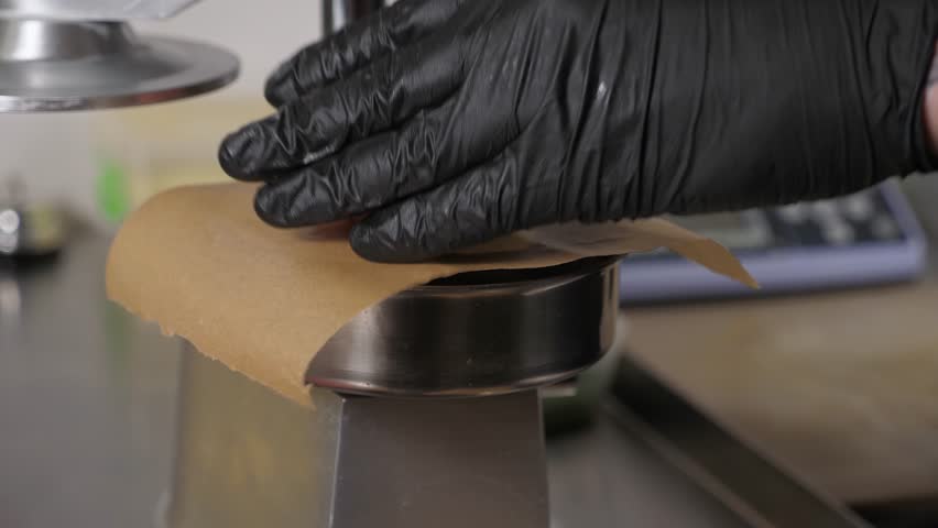 The process of cooking meat patties for a burger, a professional chef in disposable gloves prepares raw burger patties using a special burger press. Cooking burgers in a restaurant, eating. 