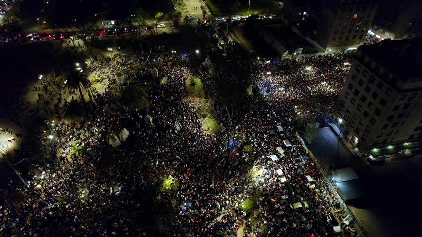 Venezuelan immigrants protest abroad People gather aerial drone fly at night in Santiago de Chile boulevard streets
