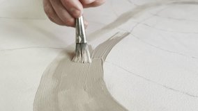 Artist creating colour lines on canvas painting with brush and beige oil paint, process of creating masterpiece in studio, abstract painting concept - Powered by Shutterstock - Get 15% off with code: PIKWIZARD15