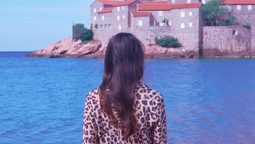 Beautiful young girl in a leopard shirt enjoying her vacation at the seaside.