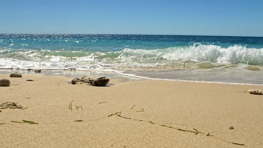 Gentle waves crashing on rocks on tropical sandy beach, Nosy Be, Nosy Fanihy, Madagaskar, Africa.