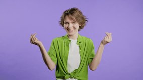 Young woman with money gesture on violet studio background. Rich lady smiling - Powered by Shutterstock - Get 15% off with code: PIKWIZARD15