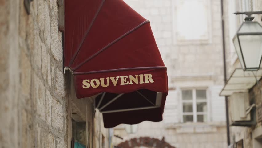 Local tourist souvenir shop with folded red roof and a sign in european old town. Souvenirs for visitors and tourists in typical small store selling items of famous landmarks gifts and local products