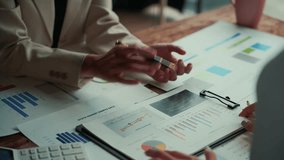 Businesswomen analyzing financial data, discussing strategies, and pointing at charts and graphs during a meeting in a corporate office environment - Powered by Shutterstock - Get 15% off with code: PIKWIZARD15