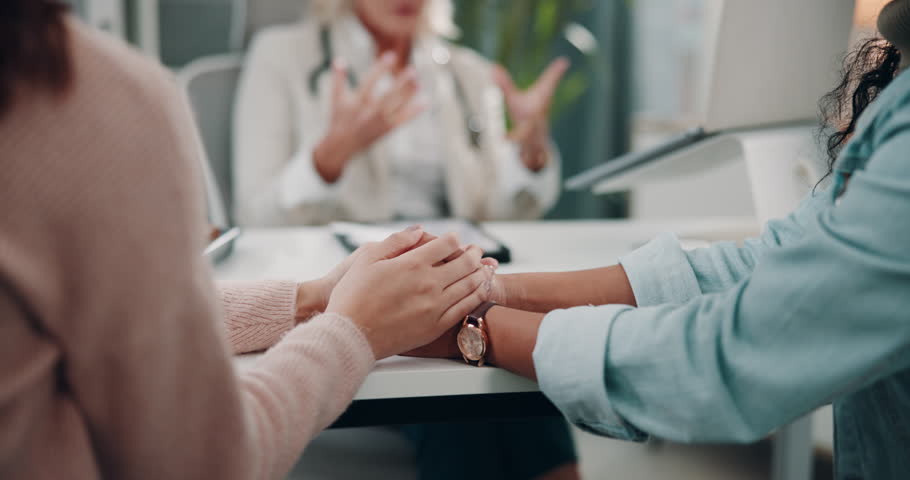 Patient, doctor appointment and holding hands for news in hospital office, results and support. Women, medical checkup and insurance for test at gynecologist, lgbtq couple and fertility or ivf choice