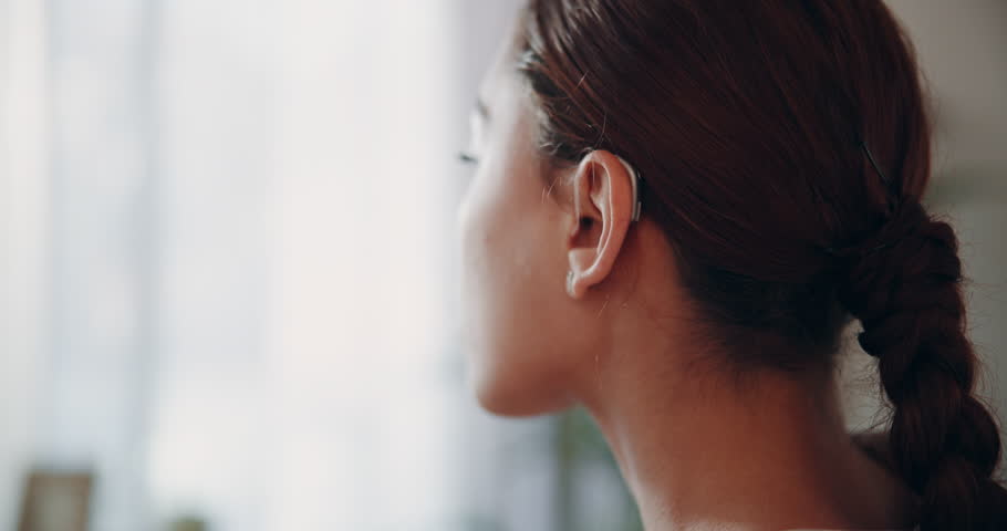 Woman, ear and hearing aid for person with a disability, listening and communication with sound waves. Female patient, deaf and audio technology for healthcare, treatment or amplifier with microphone