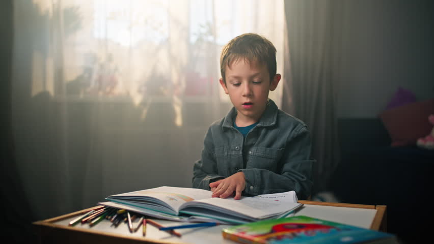 Child Reading Book in Children's Room - Close-Up of Caucasian Boy Turning Pages and Exploring. High quality 4k footage
