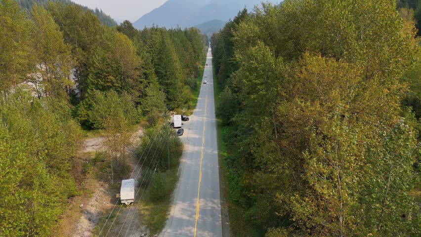 Aerial view (tilt up) of Chilliwack Lake Road along the Chilliwack River during a summer season in Chilliwack, British Columbia, Canada