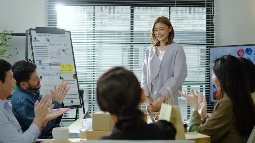 Young modern corporate Asian girl or female executive giving a presentation is appreciated or applauded by a diverse team of colleagues in a conference room meeting in a start-up office or business - Powered by Shutterstock - Get 15% off with code: PIKWIZARD15
